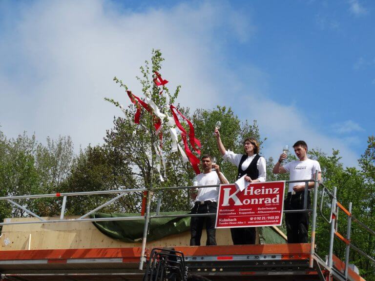 Richtfest mit Baum auf dem von den Mitarbeitern angestoßen wird