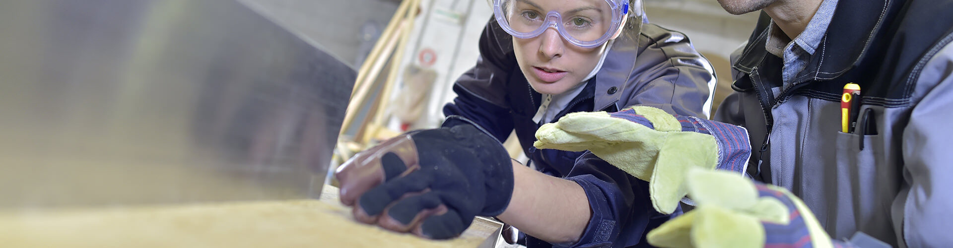 Zwei Kollegen, die gemeinsam an einem Holzbalken arbeiten