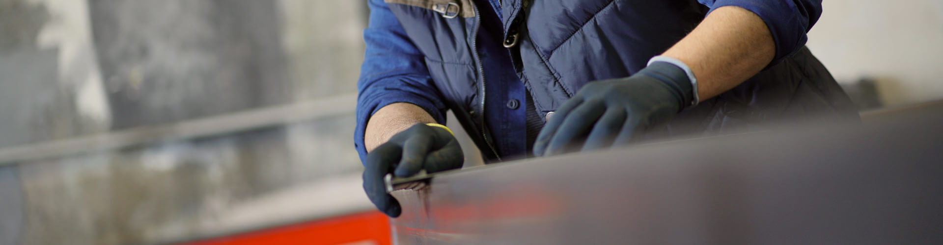 Flaschner bei präziser Metallbearbeitung, trägt Schutzbrille und Handschuhe in moderner Werkstatt